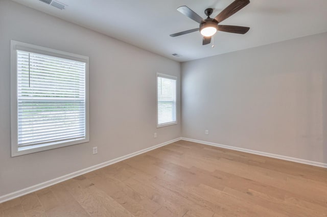unfurnished room featuring a ceiling fan, baseboards, and light wood finished floors