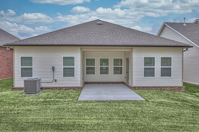 back of property with roof with shingles, central air condition unit, a lawn, and a patio