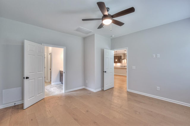 unfurnished room with light wood finished floors, a ceiling fan, and baseboards