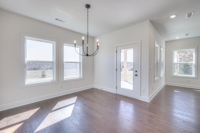 unfurnished dining area featuring a chandelier, dark wood-type flooring, baseboards, and recessed lighting