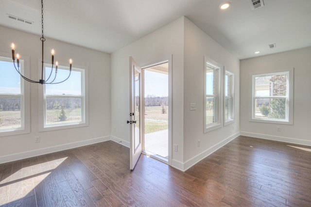 unfurnished dining area featuring a chandelier, dark wood finished floors, baseboards, and recessed lighting