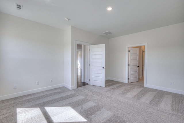 unfurnished bedroom with light carpet, baseboards, and recessed lighting