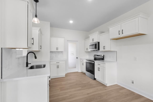 1 Shelton Ferry Rd, Southside, TN 37171 - kitchen featuring stainless steel appliances, a sink, light wood-style floors, backsplash, and light countertops