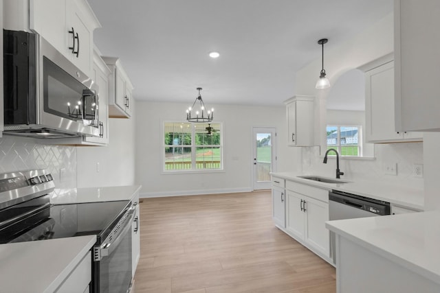 1 Shelton Ferry Rd, Southside, TN 37171 - kitchen with stainless steel appliances, a sink, light wood-type flooring, a chandelier, and decorative backsplash