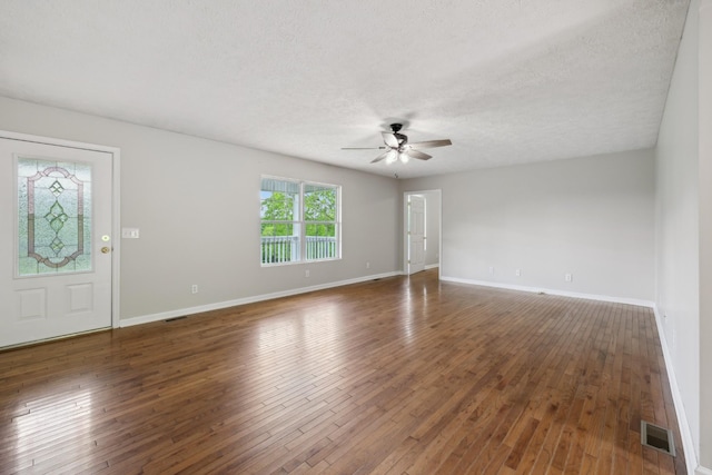 spare room with a ceiling fan, baseboards, hardwood / wood-style floors, and a textured ceiling
