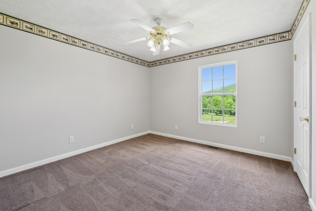 carpeted empty room with ceiling fan, a textured ceiling, and baseboards