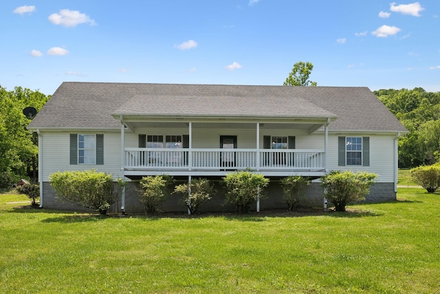 rear view of house with a lawn and roof with shingles