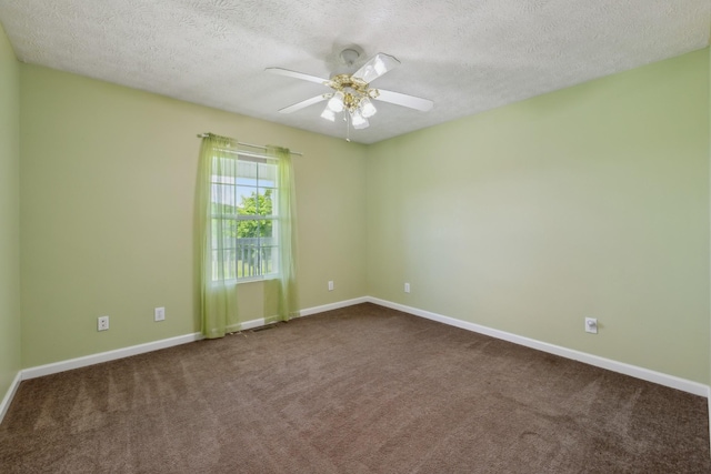 carpeted spare room featuring a textured ceiling, ceiling fan, and baseboards