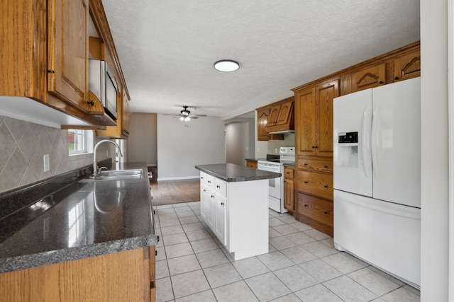 kitchen featuring white appliances, a sink, backsplash, light tile patterned floors, and a ceiling fan