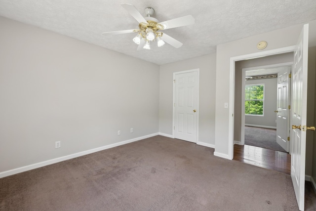 unfurnished bedroom featuring carpet flooring, baseboards, a textured ceiling, and a ceiling fan