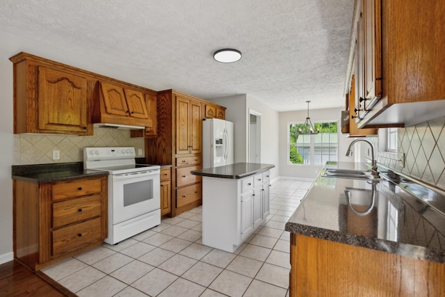 kitchen featuring white appliances, premium range hood, a sink, backsplash, and brown cabinetry