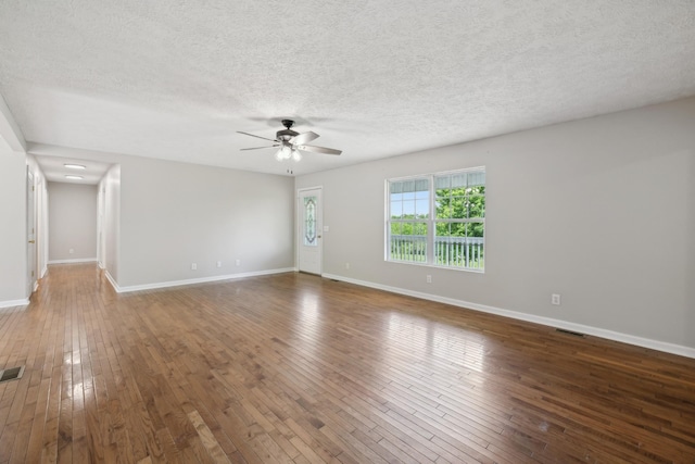 unfurnished room with a ceiling fan, hardwood / wood-style flooring, a textured ceiling, and baseboards