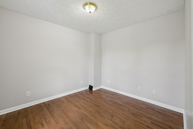 unfurnished room featuring wood finished floors, baseboards, and a textured ceiling