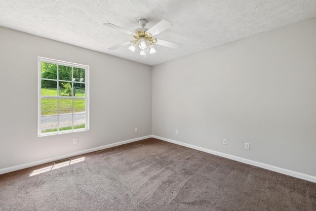 carpeted spare room with baseboards, a ceiling fan, and a textured ceiling