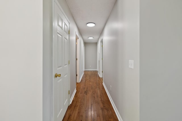 hall with hardwood / wood-style flooring and baseboards