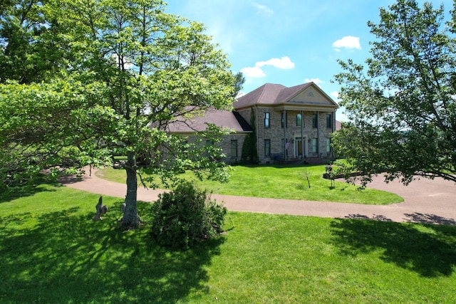 view of front facade featuring a front yard and stone siding
