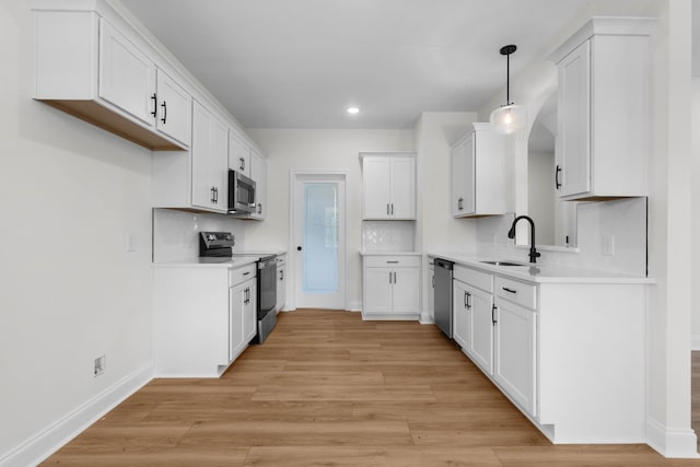 2214 S Hinton Rd, Southside, TN 37171 - kitchen with stainless steel appliances, a sink, light wood finished floors, white cabinets, and baseboards
