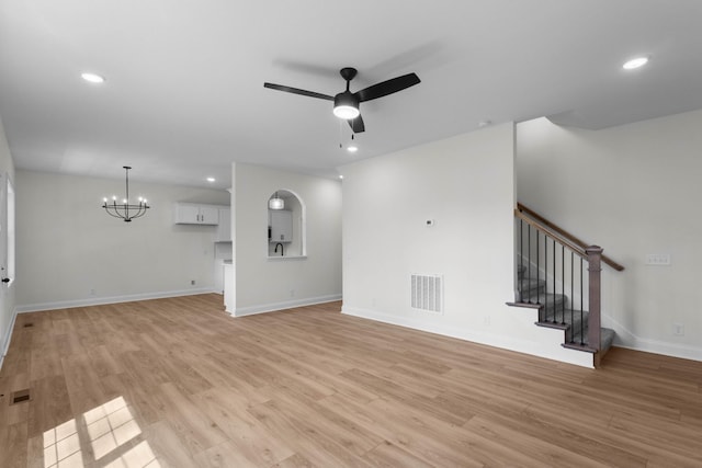 2214 S Hinton Rd, Southside, TN 37171 - unfurnished living room featuring a chandelier, a ceiling fan, light wood finished floors, stairway, and baseboards