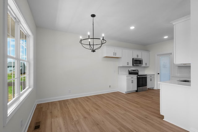 2214 S Hinton Rd, Southside, TN 37171 - kitchen with appliances with stainless steel finishes, light wood-style floors, a chandelier, white cabinetry, and recessed lighting