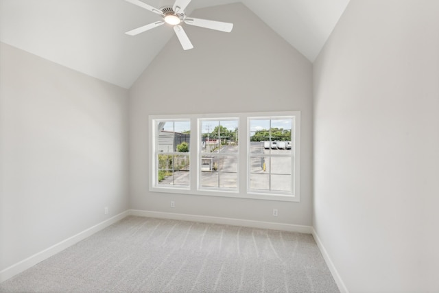 spare room featuring baseboards, light colored carpet, a ceiling fan, and high vaulted ceiling