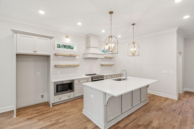 kitchen featuring built in microwave, a sink, ornamental molding, light countertops, and stainless steel range with electric cooktop