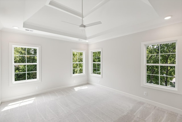 empty room with a raised ceiling, baseboards, healthy amount of natural light, and recessed lighting