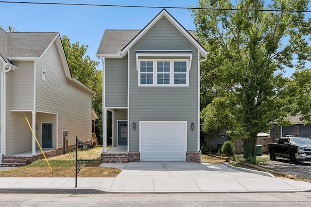 view of front of property with a garage, driveway, and a shingled roof