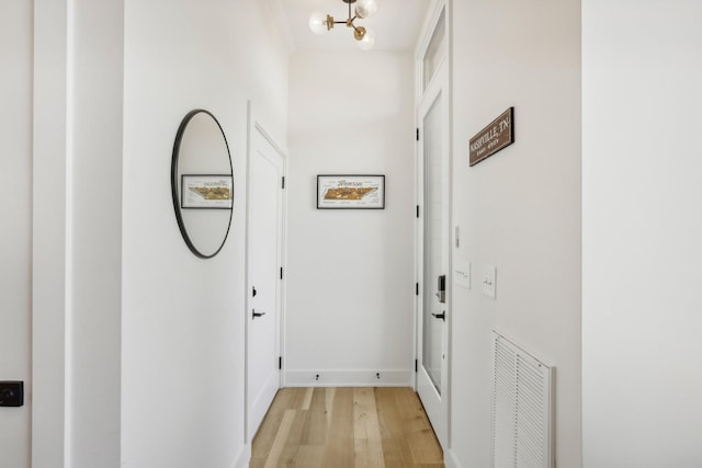 98 N 8th St, Nashville, TN 37206 - hallway featuring light wood-type flooring, a chandelier, and baseboards