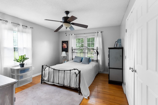 801 Lloyd St, Lawrenceburg, TN 38464 - bedroom featuring light wood finished floors, a textured ceiling, ceiling fan, and baseboards