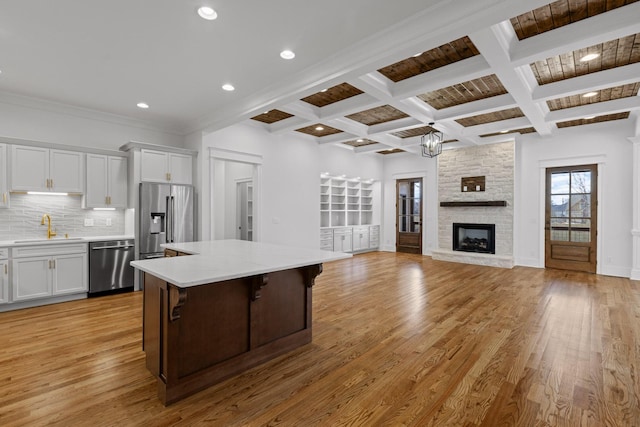 2208 Launcelot Rd, Chattanooga, TN 37421 - kitchen featuring stainless steel appliances, a sink, a kitchen island, light wood-style floors, and beam ceiling
