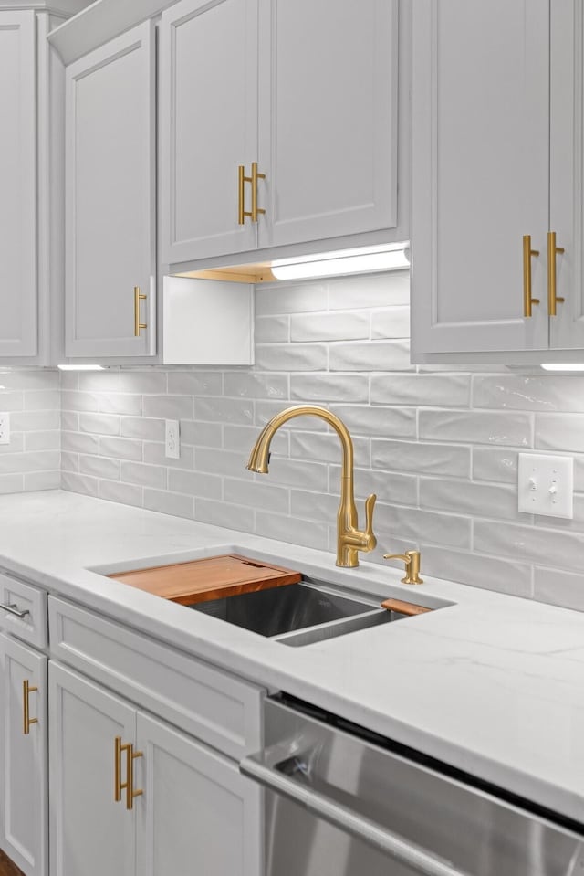 2208 Launcelot Rd, Chattanooga, TN 37421 - kitchen featuring stainless steel dishwasher, a sink, light countertops, backsplash, and white cabinetry