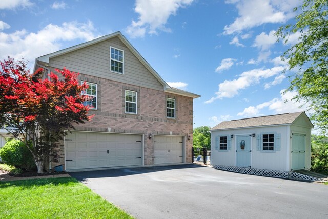 500 Mark Green Ct, Spring Hill, TN 37174 - view of front of property featuring asphalt driveway, an attached garage, an outbuilding, and brick siding