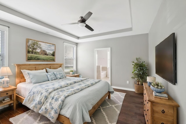160 Majestic Ln, Pleasant View, TN 37146 - bedroom featuring a tray ceiling, dark wood-style flooring, baseboards, ensuite bath, and ceiling fan