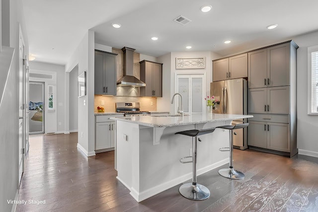 160 Majestic Ln, Pleasant View, TN 37146 - kitchen featuring wall chimney range hood, a sink, appliances with stainless steel finishes, dark wood-style flooring, and a kitchen bar