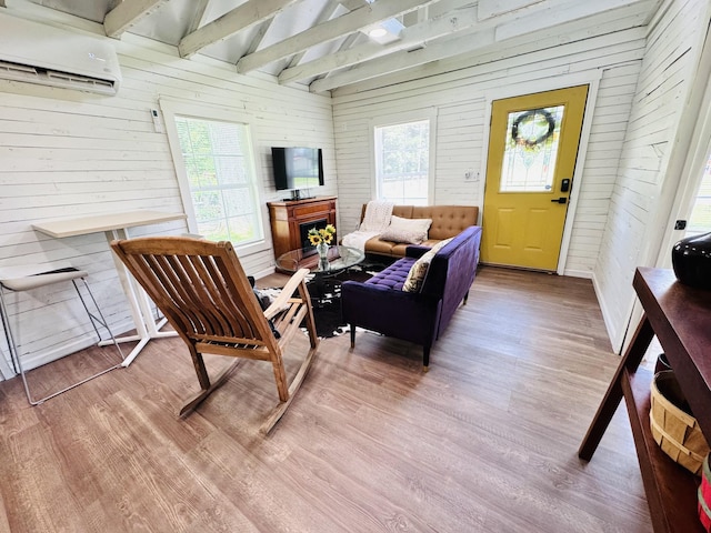 215 W College St, Bradford, TN 38316 - living area with an AC wall unit, wood finished floors, wooden walls, and plenty of natural light