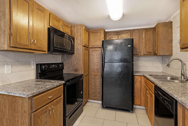 kitchen featuring black appliances, a sink, and brown cabinets