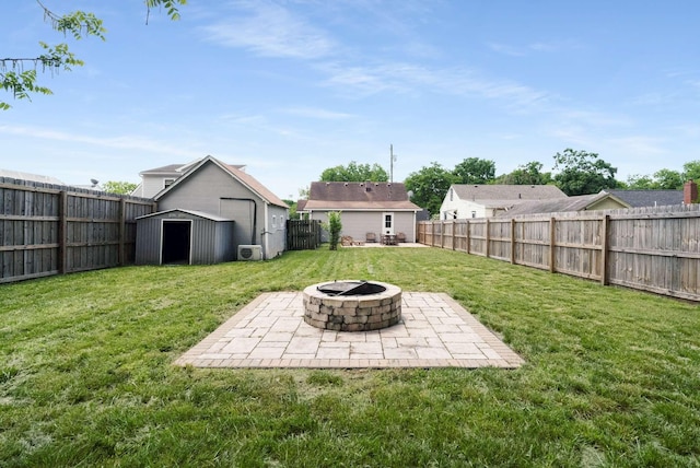 view of yard featuring a storage shed, an outdoor fire pit, a patio, and an outbuilding