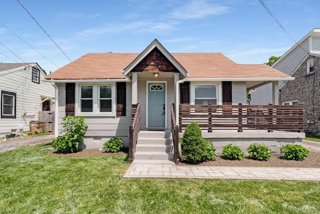 bungalow-style home featuring crawl space, covered porch, a front yard, and a shingled roof