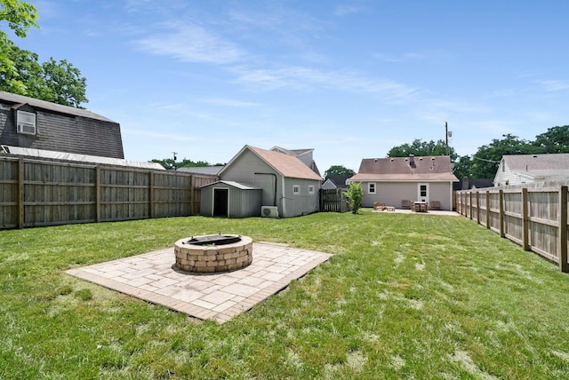 view of yard featuring an outdoor fire pit, a patio area, a storage unit, and an outbuilding