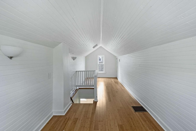 additional living space with vaulted ceiling, wooden ceiling, wood finished floors, and baseboards