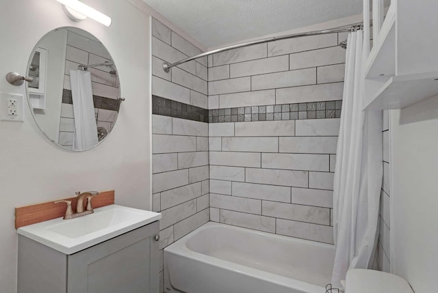 bathroom with shower / tub combo with curtain, vanity, a textured ceiling, and toilet