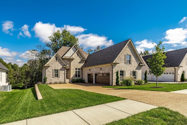 1219 Ben Forkum Dr, Lebanon, TN 37087 - view of front facade with cooling unit, concrete driveway, a front yard, brick siding, and a garage