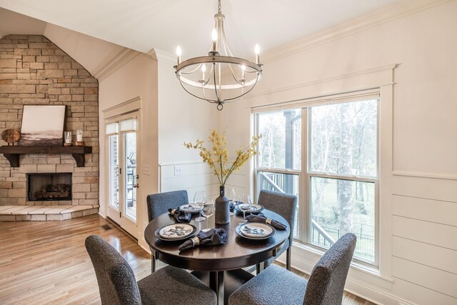 1219 Ben Forkum Dr, Lebanon, TN 37087 - dining space with a chandelier, ornamental molding, wood finished floors, a stone fireplace, and vaulted ceiling