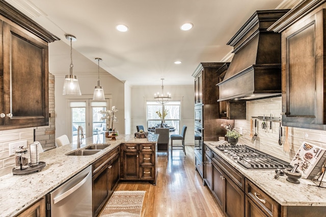 1219 Ben Forkum Dr, Lebanon, TN 37087 - kitchen featuring stainless steel appliances, a sink, light wood-style floors, tasteful backsplash, and light stone countertops