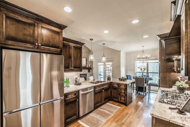 1219 Ben Forkum Dr, Lebanon, TN 37087 - kitchen with stainless steel appliances, a sink, dark brown cabinetry, light wood-style flooring, and ornamental molding