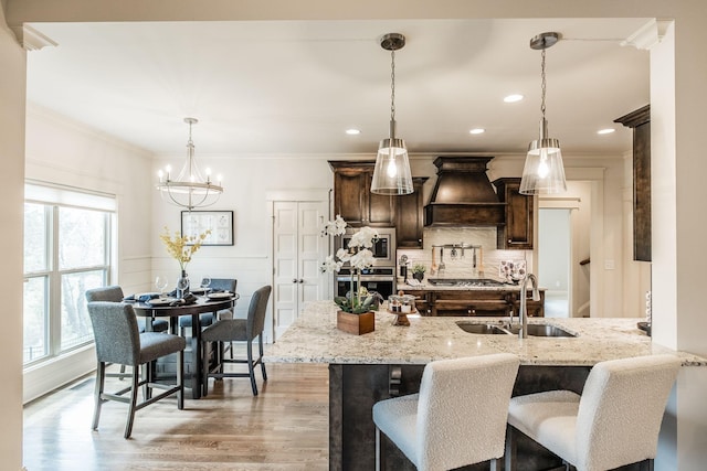 1219 Ben Forkum Dr, Lebanon, TN 37087 - kitchen featuring premium range hood, a sink, dark brown cabinets, light wood-style floors, and crown molding