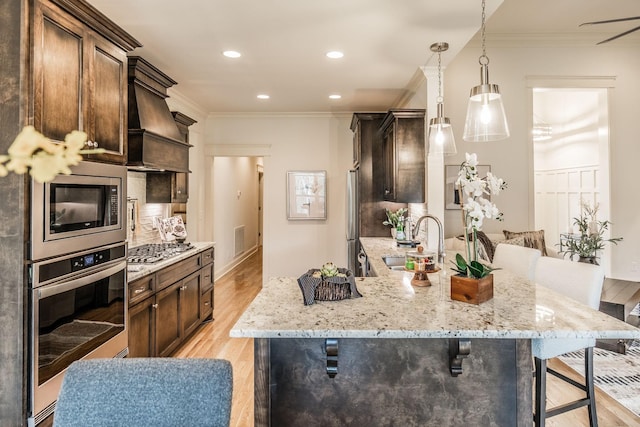 1219 Ben Forkum Dr, Lebanon, TN 37087 - kitchen featuring a sink, appliances with stainless steel finishes, custom range hood, a breakfast bar area, and ornamental molding