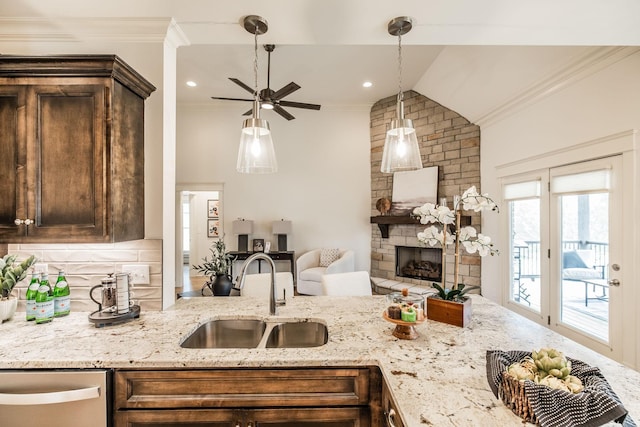 1219 Ben Forkum Dr, Lebanon, TN 37087 - kitchen with a sink, crown molding, dishwasher, a stone fireplace, and dark brown cabinetry