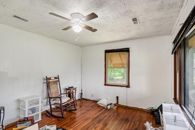 sitting room featuring wood-type flooring, a textured ceiling, and a ceiling fan