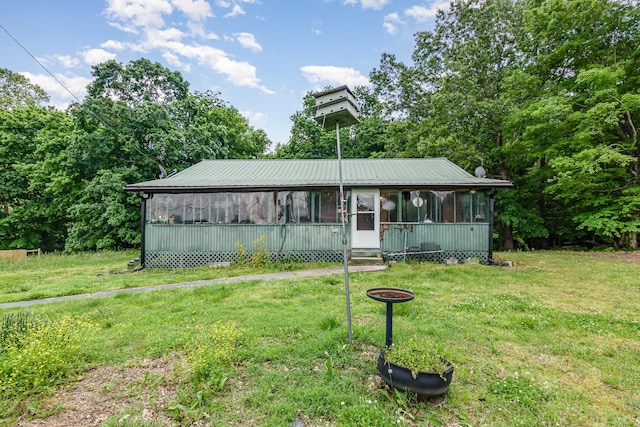 view of front of house featuring a sunroom and a front lawn